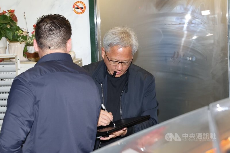 輝達(NVIDIA)執行長黃仁勳(後)16日晚間在台北鄒記食舖與台積電董事長暨總裁魏哲家等人餐敘;餐後離去前,黃仁勳維持一貫親民風格為現場粉絲簽名。中央社記者翁睿坤攝 114年5月16日