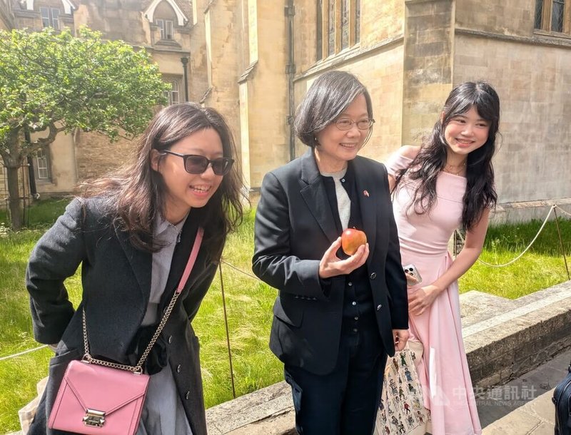 前總統蔡英文(中)16日參訪劍橋大學,期間曾拿著蘋果與劍橋大學三一學院知名地標「牛頓蘋果樹」合影。中央社記者陳韻聿劍橋攝 114年5月17日