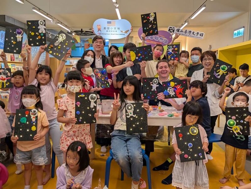 台灣文學館辦理「故事聯合國」系列活動,17日邀請美國在台協會(AIT)高雄分處長張子霖(後中右)為小朋友說故事,現場氣氛熱絡。(國立台灣文學館提供)中央社記者邱祖胤傳真 114年5月17日
