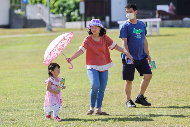 圖為台北大湖公園午後有親子開心出遊,家長在旁為孩子撐傘遮陽。(中央社檔案照片)