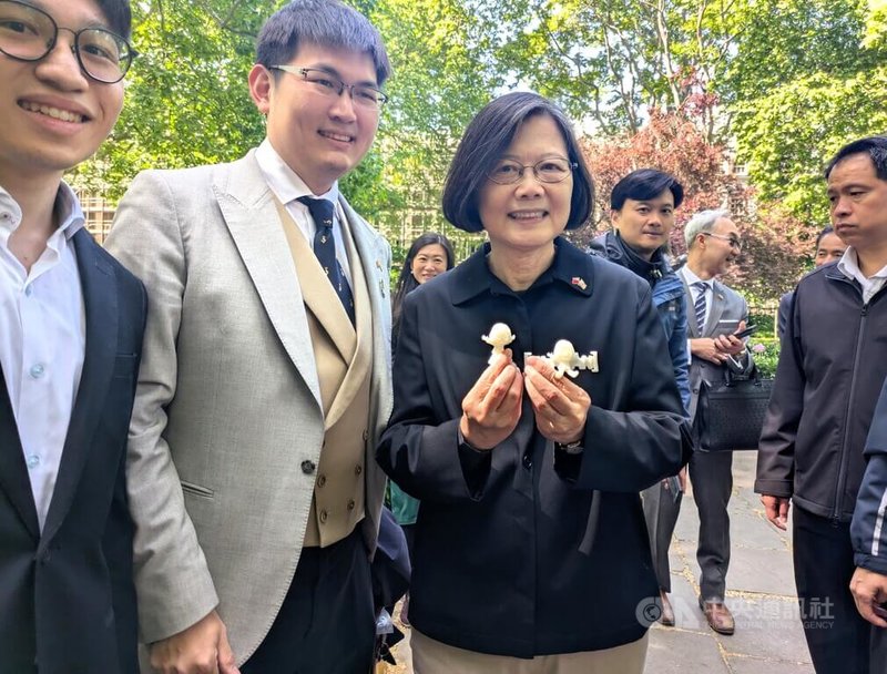 前總統蔡英文(右)17日在倫敦街頭漫步,公費留學生陳加恩(中)趨前致贈附有「小英公仔」的特製口罩減壓帶。減壓帶是台灣設計,在倫敦的醫學實驗室以3D列印技術產出。中央社記者陳韻聿倫敦攝 114年5月18日