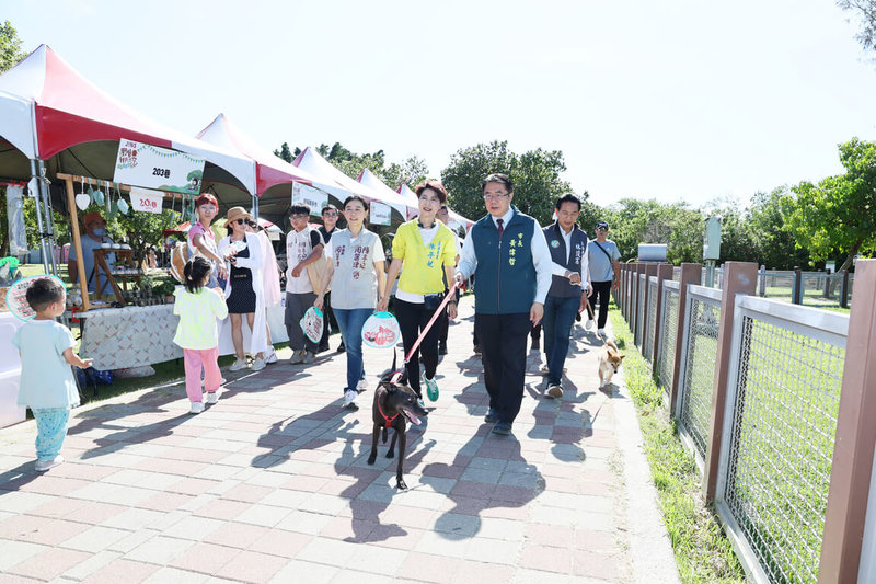 「野餐我PET你.滾草皮音樂市集」由日本眼鏡品牌JINS主辦,18日在台南市安平寵物運動公園登場,市長黃偉哲(前右)也帶著愛犬「黑妞」現身參與。(台南市政府提供)中央社記者張榮祥台南傳真 114年5月18日