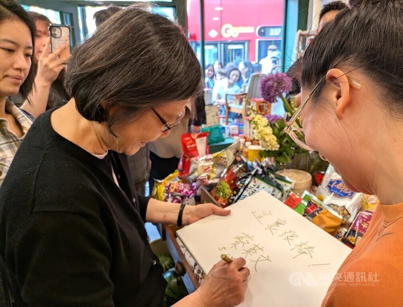 前總統蔡英文(左)18日造訪台灣人在倫敦開設的亞洲超市,為店家簽名留念,提詞「這裡很棒!」。中央社記者陳韻聿倫敦攝 114年5月19日