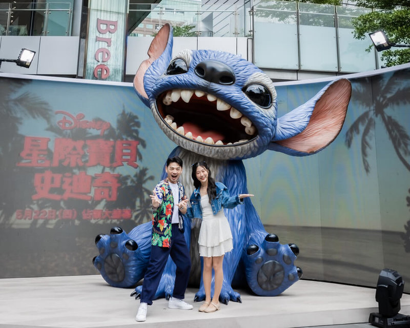 真人版電影「星際寶貝：史迪奇」即將在台上映，電影公司打造巨型史迪奇雕像，放置於台北市信義區，19日由藝人阿Ken（左）、YouTuber韓勾ㄟ金針菇（右）揭幕。（迪士尼提供）中央社記者王心妤傳真  114年5月19日
