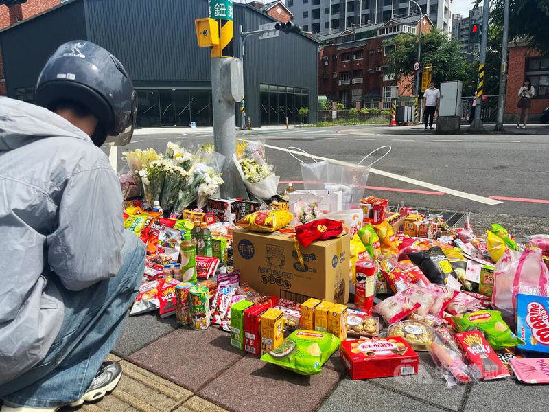 新北市三峽區北大國小外重大車禍造成3死、12傷,20日上午事故現場擺滿鮮花及零食,向逝者致意,願他們安息,並有民眾雙手合十為仍在醫院搶救的傷者祈禱,盼盡快康復。中央社記者趙敏雅攝 114年5月20日