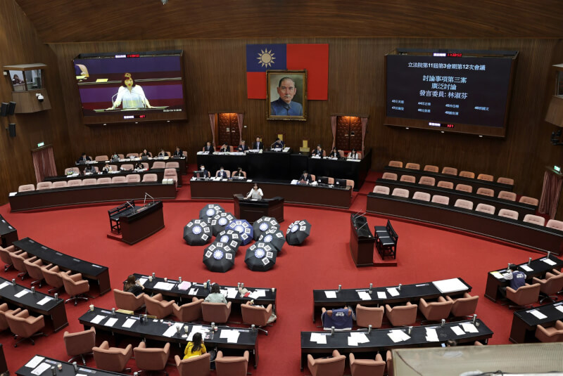 立法院會20日處理國民黨立法院黨團所提本會期延會至7月31日、反戒嚴公投等案,民進黨立委皆登記發言,並在議場擺放「國會保護傘」字樣與國民黨徽的雨傘,批評藍營是因為怕罷免才意圖延長。中央社記者裴禛攝 114年5月20日