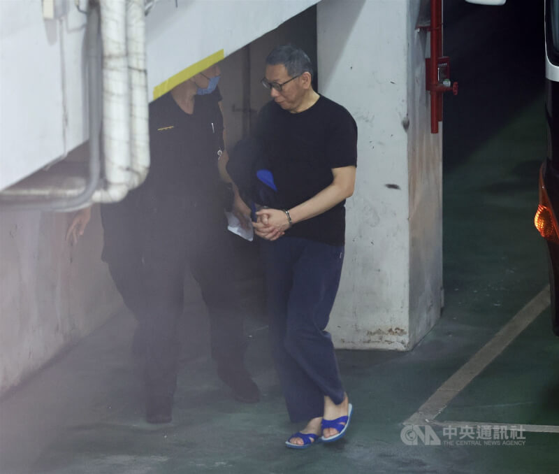 台北地方法院審理京華城案,20日提訊在押的前台北市長柯文哲(右)出庭。柯文哲穿著黑色短袖上衣、運動褲,腳踩藍白拖戴手銬抵達北院。中央社記者張皓安攝 114年5月20日