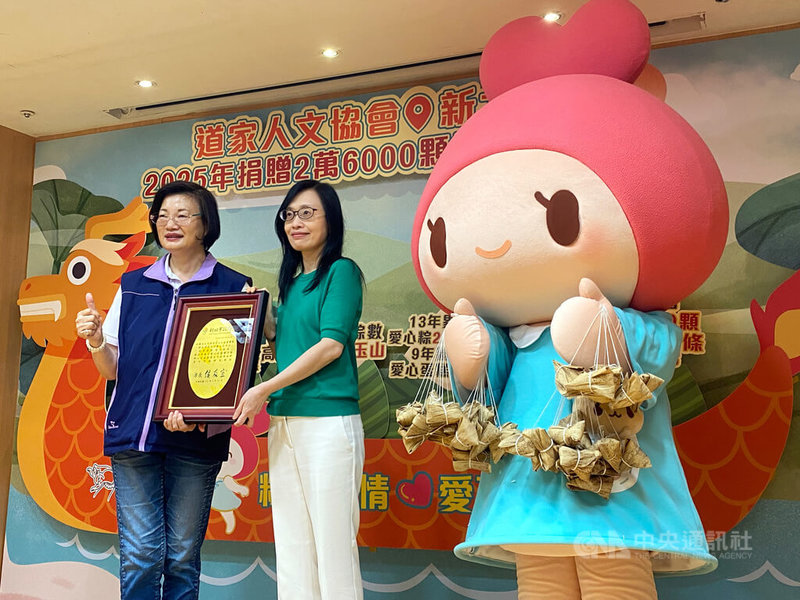 中華道家人文協會理事長張旖(左2)21日捐贈2萬6000顆愛心粽,給新北市弱勢家庭、獨居老人及寄養家庭兒童,新北市社會局長李美珍(左)代表接受,並回贈感謝牌。中央社記者黃旭昇新北市攝 114年5月21日