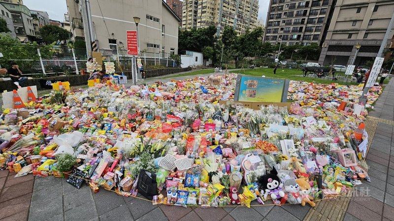 新北市三峽區19日發生重大傷亡車禍,許多民眾主動獻花,事發路口的公園陸續擺滿了各種零食飲料、鮮花及可愛玩偶。中央社記者王鴻國攝 114年5月21日