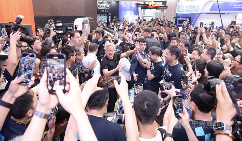 2025台北國際電腦展(COMPUTEX 2025)20日起在台北南港展覽館盛大開展,輝達(NVIDIA)執行長黃仁勳(中左)親自走訪參觀,在和碩攤位被滿滿人潮包圍,眾人紛紛高舉相機、手機搶拍。中央社記者張新偉攝 114年5月20日