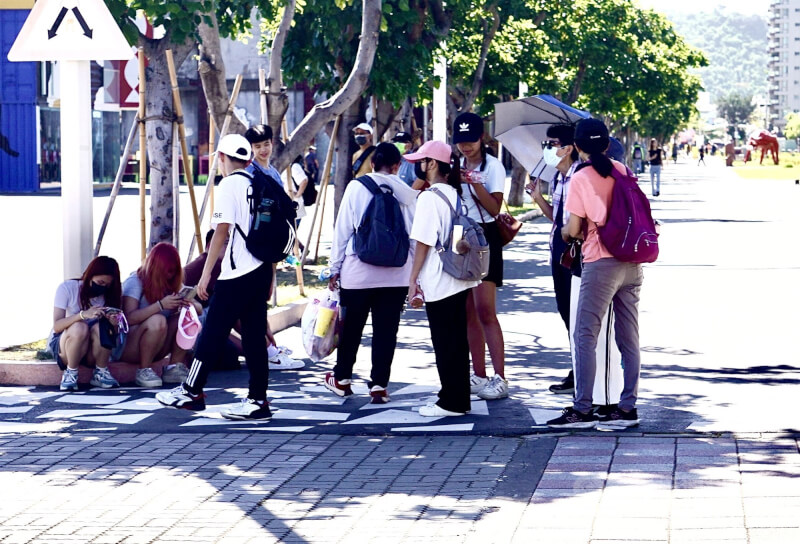 圖為高雄市鹽埕區景點民眾在樹蔭下躲避豔陽直射。(中央社檔案照片)