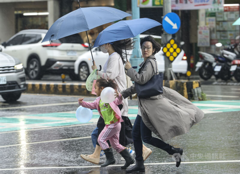 圖為新北市民眾撐傘快步過馬路。(中央社檔案照片)