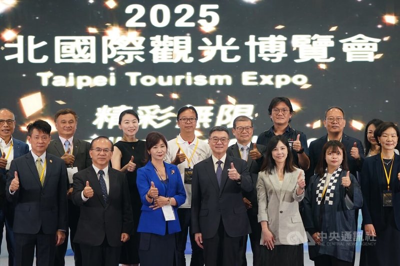 行政院長卓榮泰(前排中)23日上午在台北世貿出席2025台北國際觀光博覽會開幕典禮,與來賓一同啟動儀式、比讚合影。中央社記者徐肇昌攝 114年5月23日