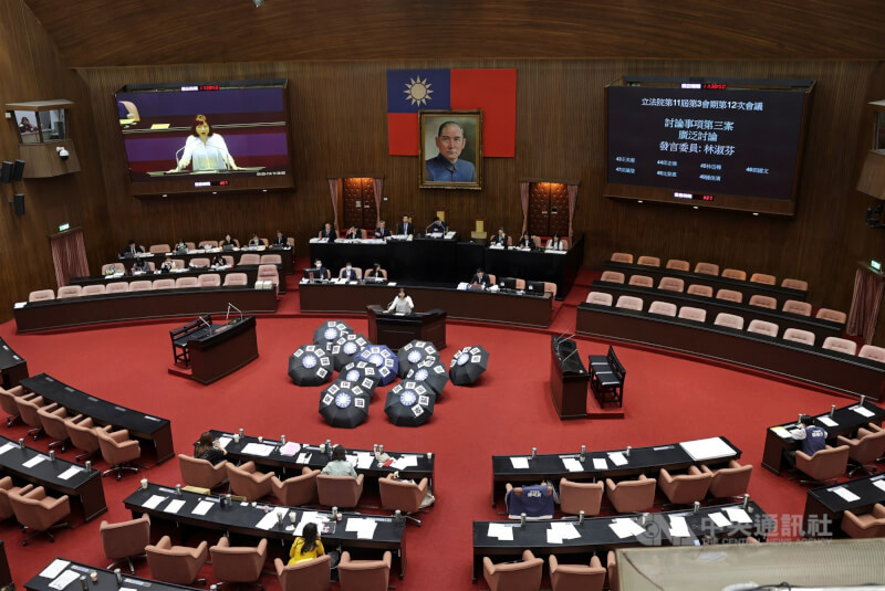 圖為立法院會20日處理國民黨立法院黨團所提反戒嚴公投等案,民進黨立委在議場擺放「國會保護傘」字樣與國民黨徽的雨傘。(中央社檔案照片)