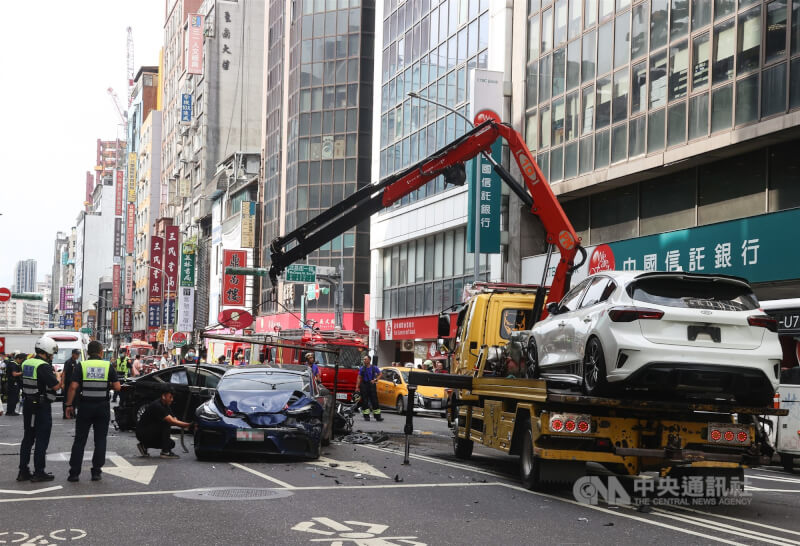 一輛自小客車23日下午在台北市重慶南路上不明原因失控暴衝,多輛汽車遭撞受損,現場交通一度受阻,肇事原因仍有待進一步釐清。圖為拖吊車到場拖離事故車輛。中央社記者謝佳璋攝 114年5月23日