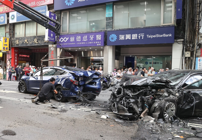 台北市重慶南路一段23日下午發生車禍事故，現場黑色自小客車頭與藍色自小客車尾嚴重毀損，拖吊車已出動到場協助排除。中央社記者謝佳璋攝 114年5月23日