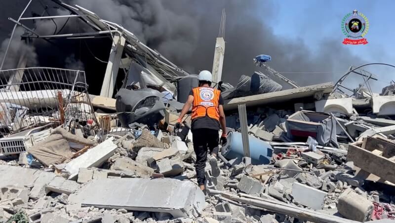 以色列空襲加薩南部汗尤尼斯後,救護人員在廢墟中搜尋生還者。(Palestinian Civil Defence/Handout via 路透社)