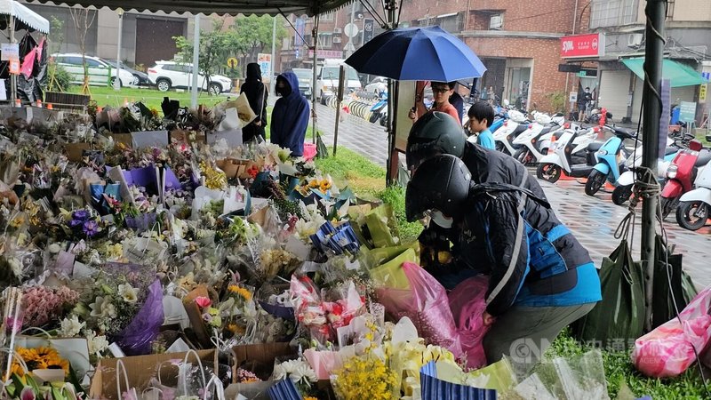 新北市三峽區19日發生重大車禍釀死傷,各地民眾連日到事發地旁的公園獻花表達哀思。圖為民眾25日冒雨獻花表哀思。中央社記者王鴻國攝 114年5月25日