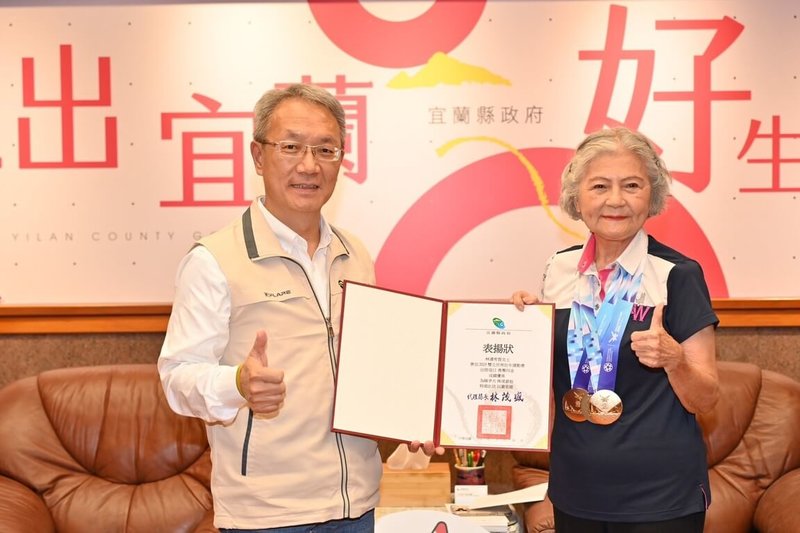 有「噴射機阿嬤」美譽的88歲林潘秀雲(右),曾因韌帶傷勢幾乎無法行走,她選擇靠運動復健,經歷3年努力重返跑道,在2025雙北世壯運拿下4面金牌,宜蘭縣代理縣長林茂盛(左)26日接見表揚。(宜蘭縣政府提供)中央社記者王朝鈺傳真 114年5月26日