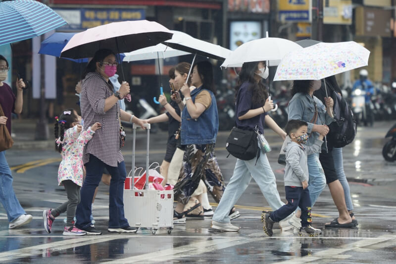 圖為台北西門町,民眾撐傘過馬路。(中央社檔案照片)