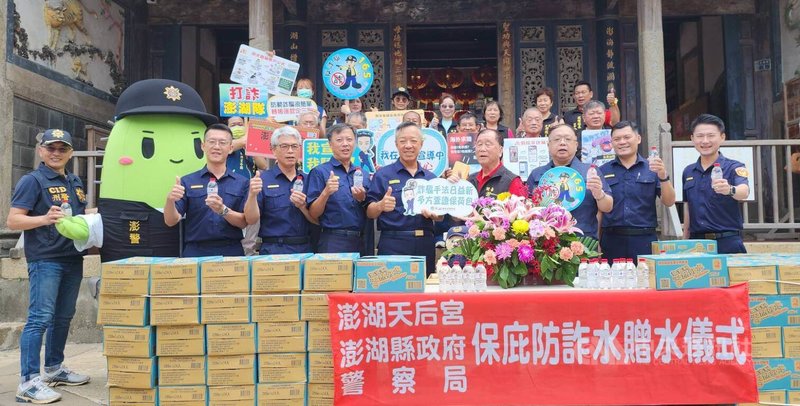 澎湖天后宮「保庇防詐水」贈水儀式,28日在天后宮前往廣場舉行,主委蔡光明(前右4)捐贈印有「保庇防詐水」字樣的瓶裝水,澎湖縣警局長林温柔(前右5)率所轄3個分局長等代表接受,並回贈感謝狀給天后宮,現場也正好大批遊客前往參觀,分享了防詐水保佑。中央社 114年5月28日