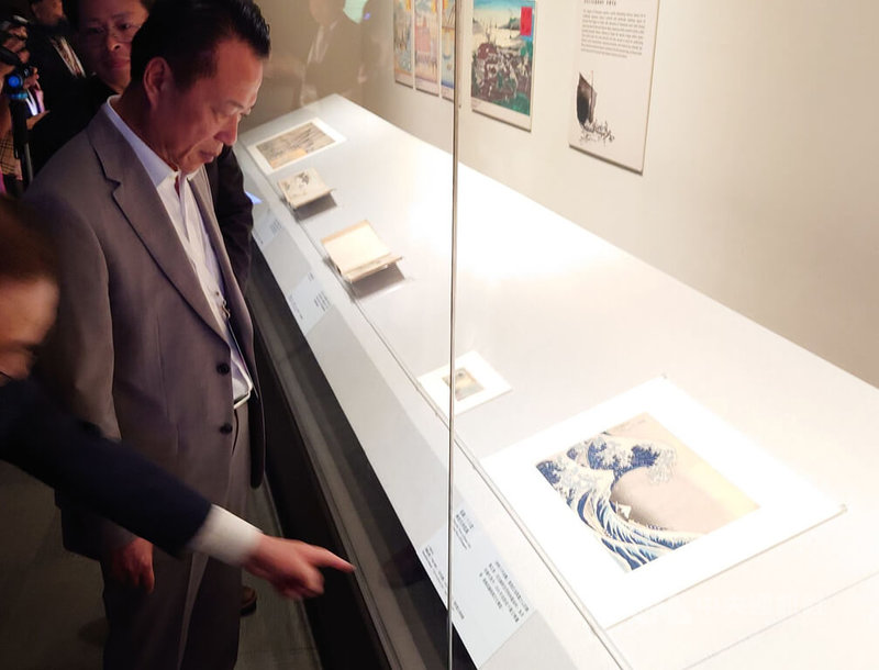 日本江戶時代浮世繪畫家葛飾北齋經典作品「富嶽三十六景:神奈川沖浪裏」30日起將在故宮南院特展「江戶浮世之美」中限期展出,29日舉辦開展記者會,嘉義縣長翁章梁(左)等人先賭為快。中央社記者蔡智明攝 114年5月29日