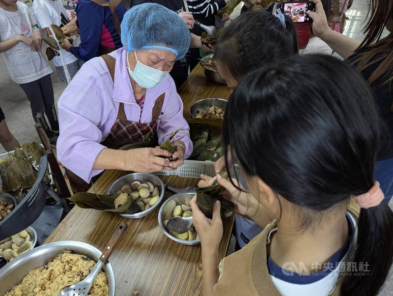 端午佳節將至,金門縣金寧鄉古寧頭社區發展協會29日舉行「青銀包粽文化傳承與長者關懷」活動,由社區長輩擔任文化傳承者,教導年輕世代學習包粽技藝。中央社記者吳玟嶸攝 114年5月29日