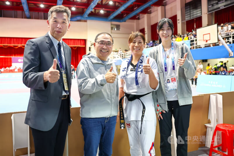 2025年雙北世界壯年運動會跆拳道個人對打賽事29日在新北市板樹體育館登場,跆拳道國手羅嘉翎(右1)的母親何千金(右2)以選手身分參賽,羅嘉翎父親羅文祥(左1)及新北市長侯友宜(左2)都到場觀賽加油。中央社記者王騰毅攝 114年5月29日