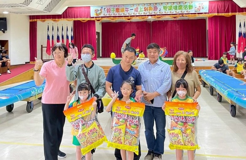 澎湖縣湖西鄉公所30日與鄉立幼兒園與圖書館共同舉辦「親子慶端午.陸上划舟趣」活動,以SUP立槳板改裝為陸上龍舟,有80對親子分組下場齊力比划,鄉長陳振中(2排右2)頒獎給優勝者。(澎湖湖西鄉公所提供)中央社 114年5月30日