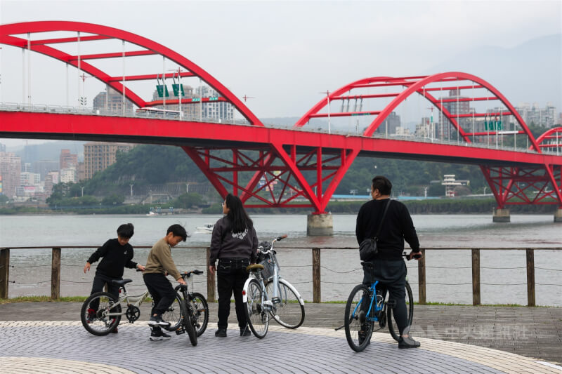 圖為民眾在關渡大橋旁悠閒地騎腳踏車。（中央社檔案照片）