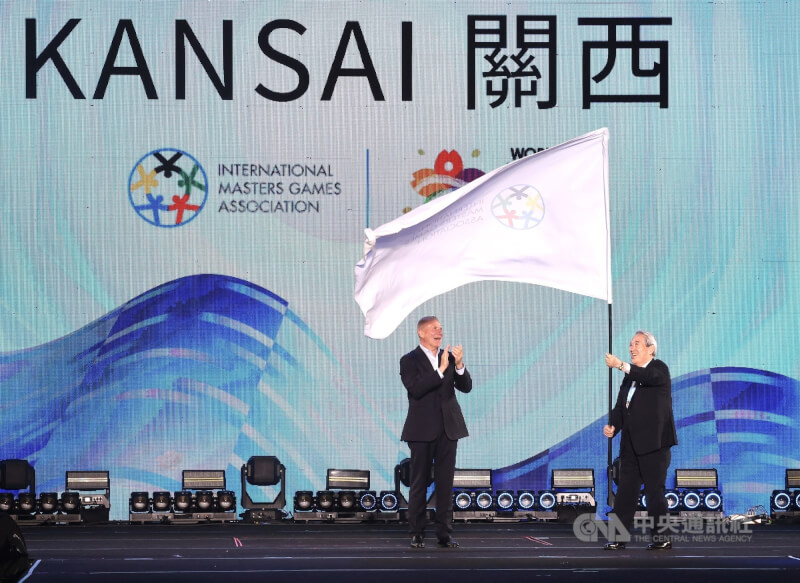 2025雙北世壯運閉幕典禮30日晚間在新北市美術館舉行,會中進行國際壯年運動總會(IMGA)會旗交接儀式,由下屆主辦城市、日本關西世壯運組委會會長松本正義(右)接下會旗。中央社記者趙世勳攝 114年5月30日