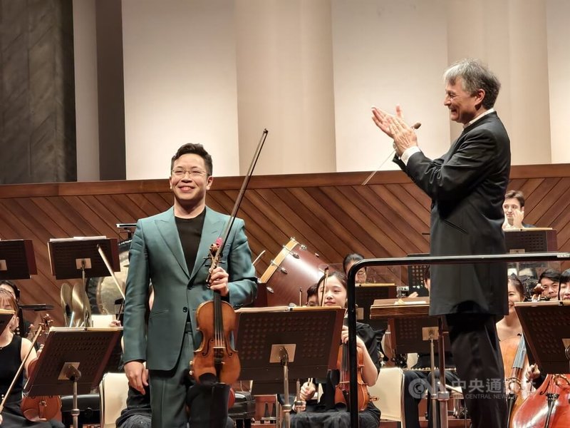 NSO國家交響樂團31日在日本熊本縣立劇場舉行「來自台灣」日本巡演音樂會首場演出,指揮準.馬寇爾(Jun Märkl)(右)與小提琴家黃俊文(左)首度合作演出貝多芬「D大調小提琴協奏曲」。中央社記者趙靜瑜攝 114年5月31日