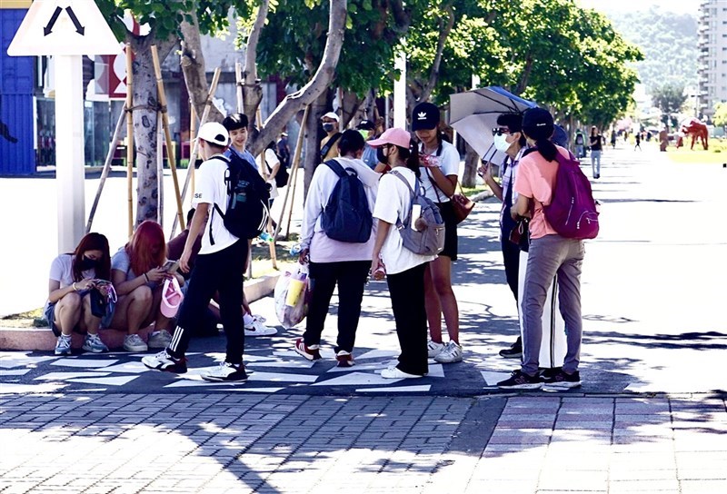 圖為高雄市鹽埕區景點民眾在樹蔭下躲避豔陽直射。(中央社檔案照片)