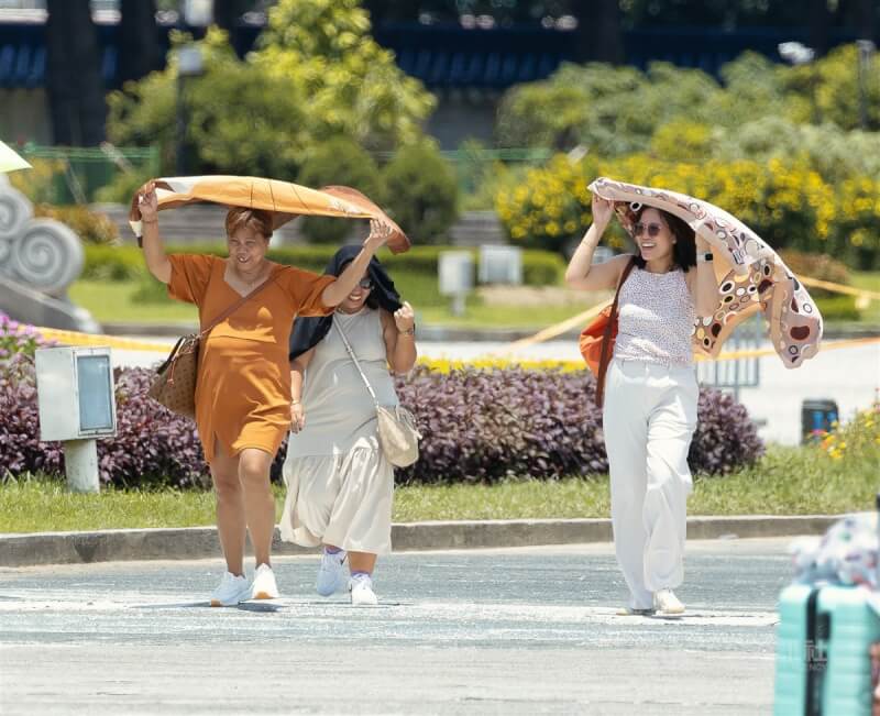 圖為民眾在中正紀念堂以披巾遮擋豔陽。(中央社檔案照片)