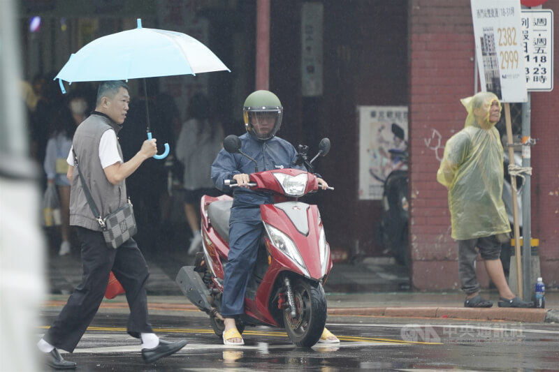 圖為台北西門町午後陰雨綿綿,路上行人撐傘、穿上雨衣擋雨。(中央社檔案照片)