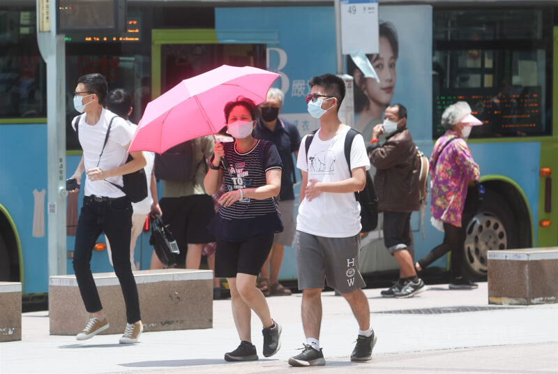 台北市中正區街頭的民眾撐傘遮陽。(中央社檔案照片)