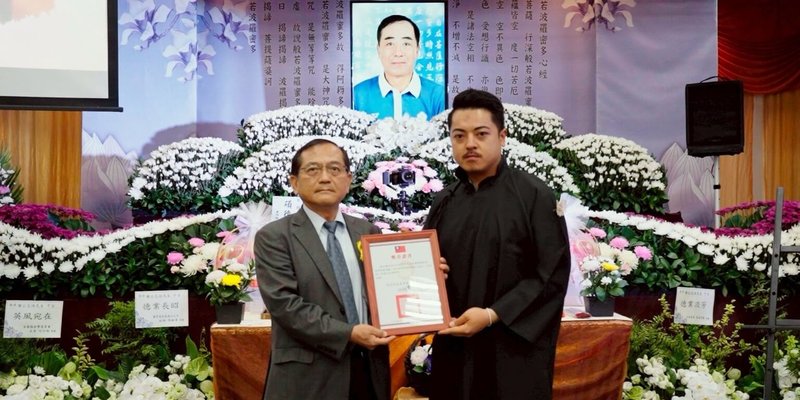 原住民族委員會為表彰已故前國家射擊代表隊謝志培發展台灣射擊運動的貢獻，3日原民會副主委鍾興華Calivat．Gadu（左）於其告別式中追頒二等原住民族獎章，並由謝志培的兒子李孟遠（右）代表接受。（原民會提供）中央社記者張雄風傳真  114年6月3日