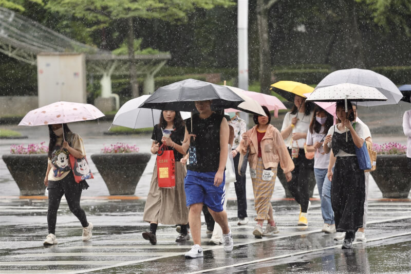 滯留鋒面及西南風影響，中央氣象署3日持續發布大雨特報。圖為台北市信義區街頭民眾快步過馬路。中央社記者王飛華攝  114年6月3日