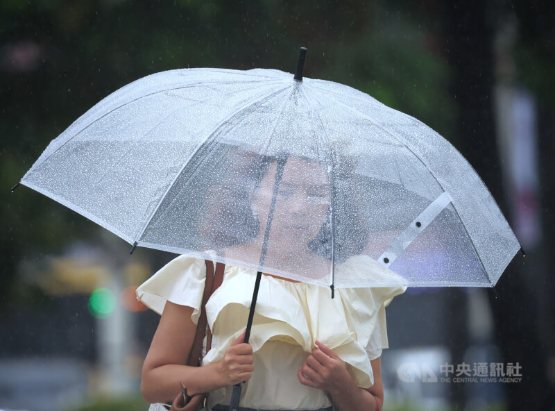 氣象署表示,3日晚至4日清晨,南部地區仍有豪雨。圖為台北市中正區,民眾外出撐傘擋雨。(中央社檔案照片)