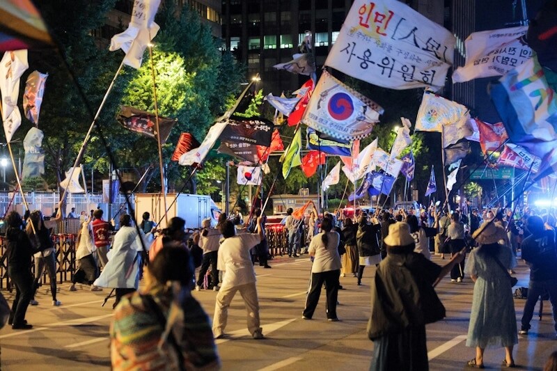 李在明支持者在光化門廣場外揮舞旗幟。(路透社)