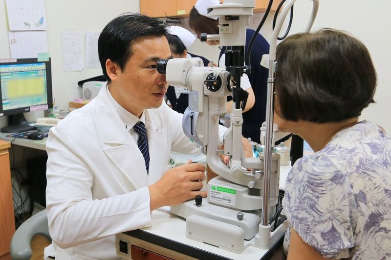 53歲張女士左眼黃斑部裂孔,經3次手術仍未癒合,花蓮慈濟醫院眼科部視網膜科主任何明山(左)檢查發現為極罕見的雙裂孔,採創新雙重療法治療,以羊膜移植修補破洞,並輔以自體高濃度血小板血漿(platelet-rich plasma,PRP)注射,促進組織修復與裂孔癒合。(花蓮慈濟醫院提供)中央社記者李先鳳傳真 114年6月5日