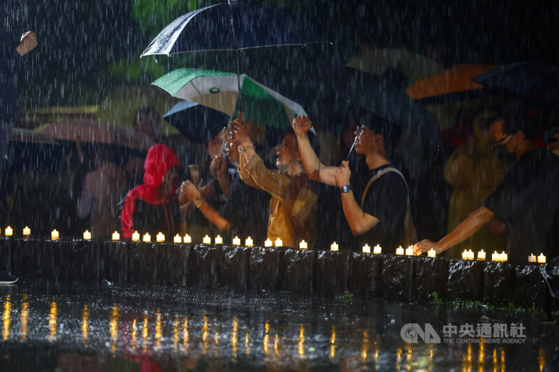 「在台港人六四燭光晚會」儘管過程中一度下起大雨,現場參與者仍撐傘冒雨響應,為主辦方加油打氣。中央社記者王騰毅攝 114年6月4日