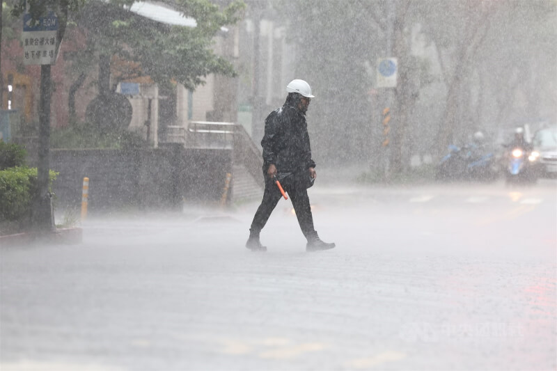 圖為台北市內湖區一處工區人員穿著雨衣在大雨中指揮引導。中央社記者翁睿坤攝 114年6月7日