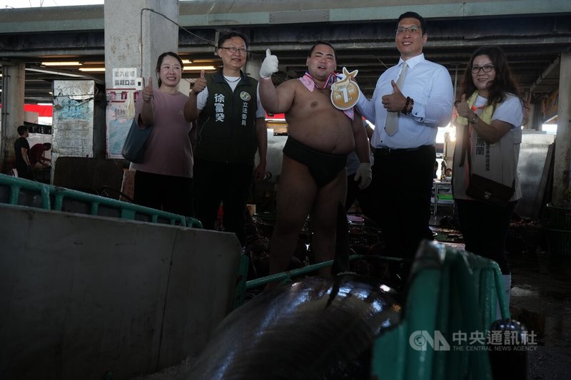 錣山部屋力士造訪屏東,展開一系列文化觀光交流,9日現身東港魚市場,台日雙方進行「拖魚PK賽」,由力士御雷山(中)代表與民進黨立委徐富癸(左2)對決,最後由御雷山先行抵達,奪得冠軍徽章。中央社記者黃郁菁攝 114年6月9日