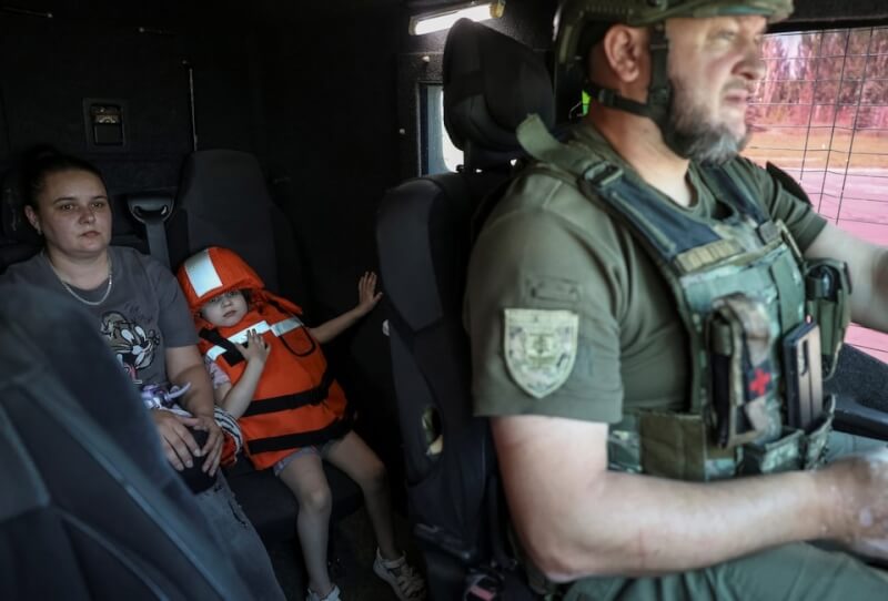 烏克蘭頓內茨克區1名軍人7日帶著一對母女撤離前線。(路透社)
