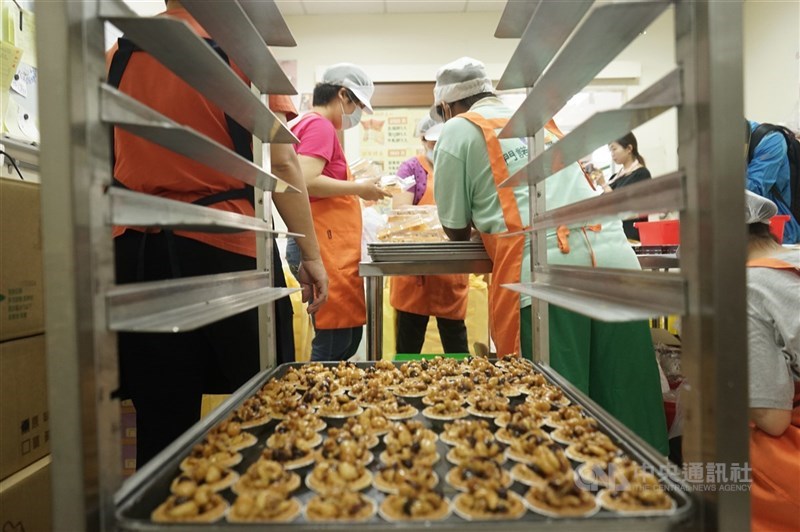 圖為庇護工場員工趕工禮盒商品。(中央社檔案照片)