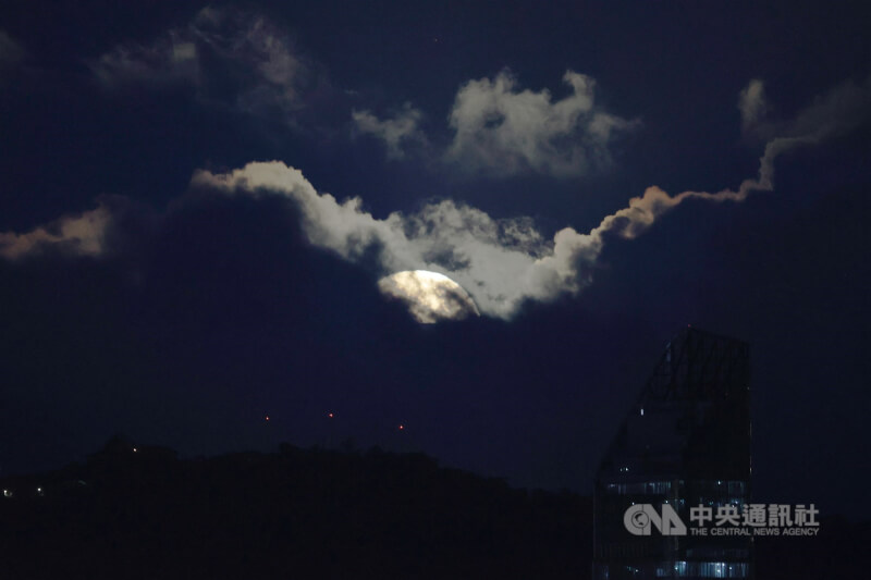 許多天文迷引頸期盼的2025年草莓滿月11日傍晚突破雲層登場,雖然每年6月的滿月都可以稱作草莓月亮,不過今年的草莓月亮是近20年來視角最低的一次。中央社記者孫仲達攝 114年6月11日