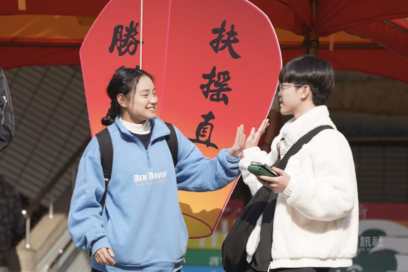 圖為學科能力測驗考生們步出考場後,互相開心擊掌。(中央社檔案照片)