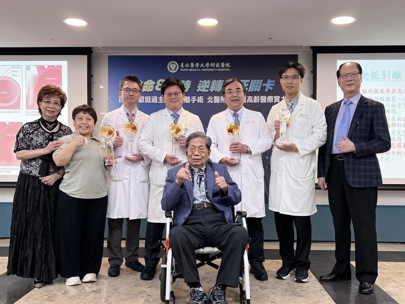已有百歲高齡的蔡爺爺(乘坐輪椅者)幾乎每天爬山,今年卻突然發生急性主動脈剝離,台北醫學大學附設醫院派出2名主治醫師聯手執刀,成功助蔡爺爺脫離鬼門關。(北醫附醫提供)中央社記者曾以寧傳真 114年6月12日
