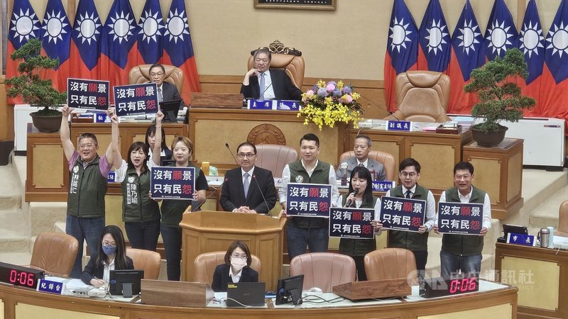 新北市長侯友宜(立者左4)12日列席新北市議會備詢,民進黨籍議員聯合質詢時抨擊侯友宜2022年提出「2030願景工程」是願景變「怨景」,並到侯友宜身邊高喊「沒有願景,只有民怨」口號。中央社記者王鴻國攝 114年6月12日